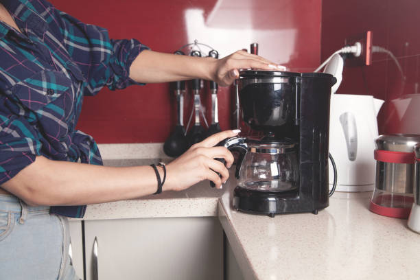 istock Woman making coffee in a coffee maker machine. 1313250807
