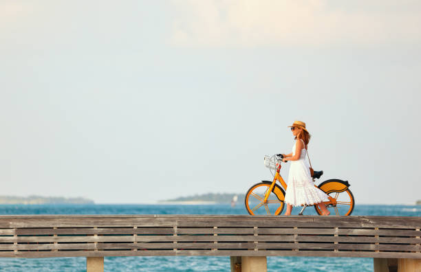Woman walking with bicycle along promenade