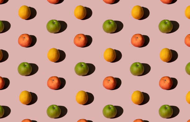istock Bright colorful summer fruit pattern made with fresh green apple, lemon and mandarin orange or tangerine. Flat lay on pink pastel background, linear, geometric. 1313252175