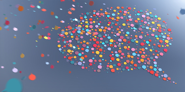 Lots of multi-coloured speech bubble icons falling from above at speed with motion blur, and gathering together to form a larger speech bubble speech on a plain background.