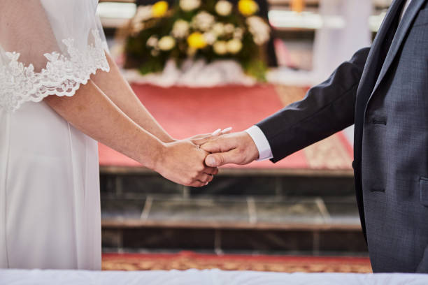 istock Newlyweds hold hands during a wedding in a catholic church 1313253737