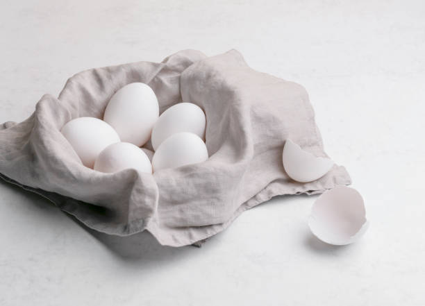 istock Basket of white eggs on a gray linen cloth on white marble background 1313253744