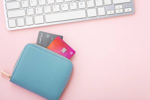 istock Credit card in purse with computer keyboard on pink background 1313256107