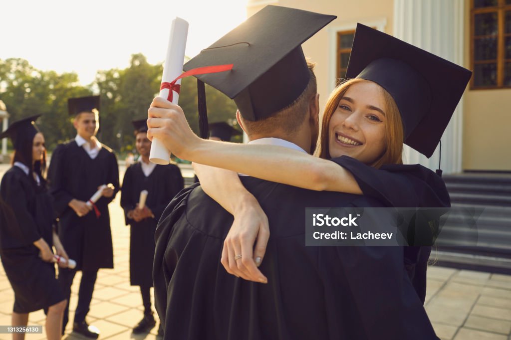 Feliz Pareja De Graduados Universitarios En Bonets Tradicionales De Pie Con  Diplomas Y Abrazándose Unos A Otros Foto de stock y más banco de imágenes  de Graduación - iStock