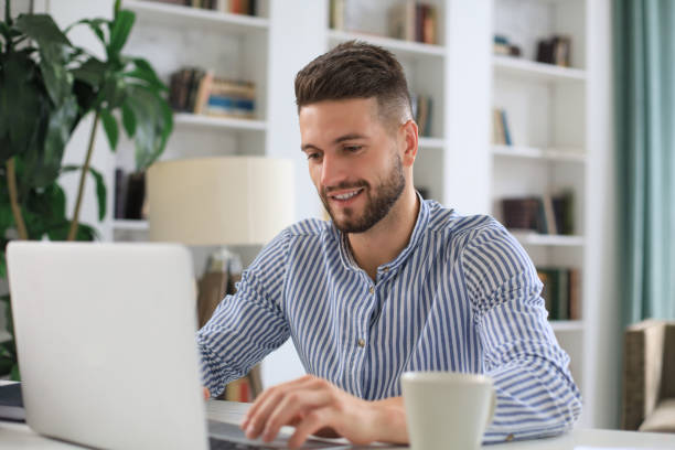 istock Happy young business man is analizing financial documents from home during self isolation. 1313258382