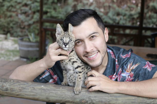 Man with baby serval cat