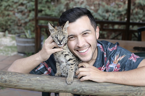 Man with baby serval cat.