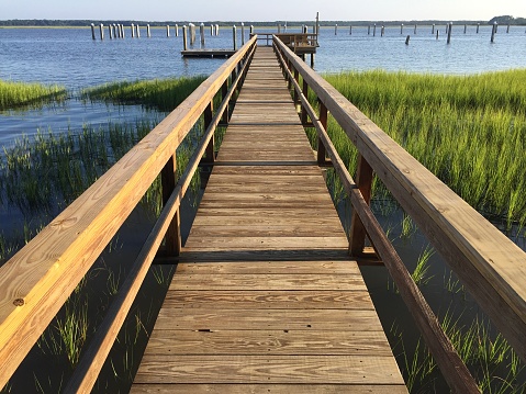 Wooden boardwalk leading to a boat landing and estuary in South Carolina, USA