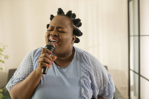 istock Woman holding microphone while performing her favorite song at karaoke 1313261624