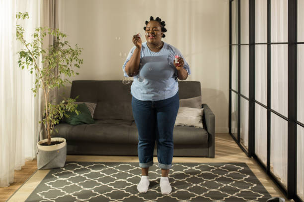 istock Woman having fun with soap bubbles while standing at her cozy flat 1313261702