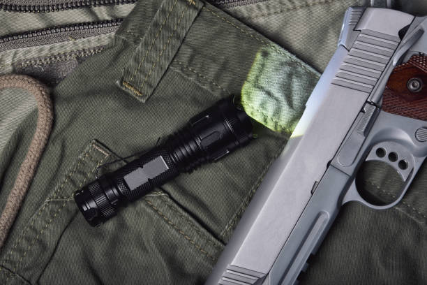 istock Weapons and military gun equipment for army with tactical flashlight, Semi-automatic 1911 model handgun, .45 pistol on green military uniform background. 1313263537