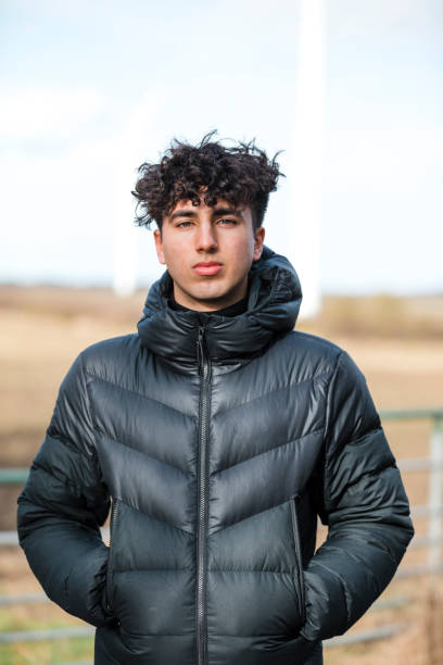 Teenage Boy Portrait Front view portrait of a mixed race teenage boy standing in a rural location looking at the camera with his hands in his pockets. 18 19 years stock pictures, royalty-free photos & images