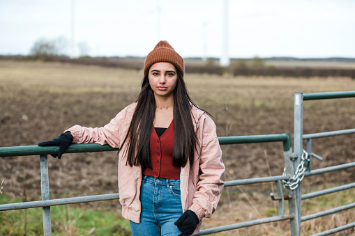 Front view portrait of a mixed race teenage girl standing in a non urban area looking at the camera.