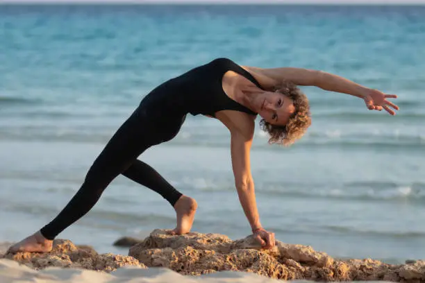 woman in yogapose on the beach