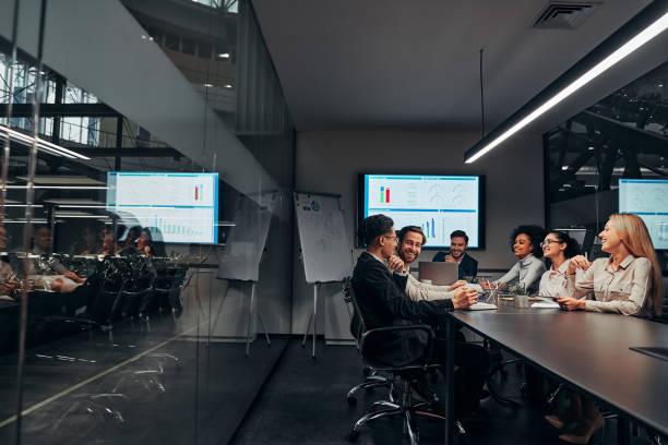 istock Group of successful smiling business people discussing work in a spacious conference office. Presentation. Data analysis, statistics, finance.Business team.Copy space. 1313264870