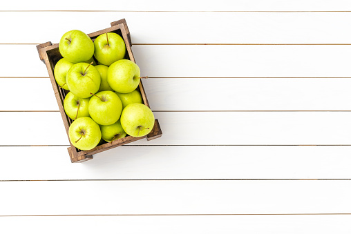 Overhead shot of green apples on wooden table