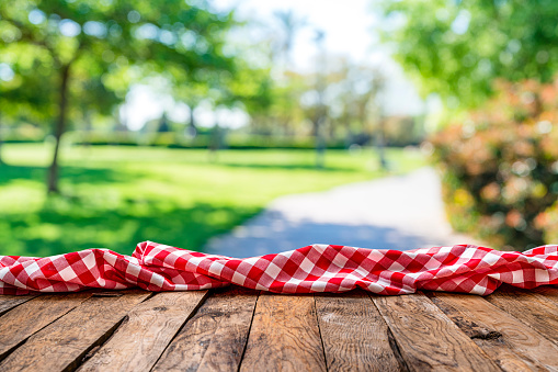 Empty table with crumpled gingham tablecloth outdoors
