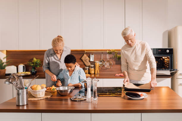 istock Man standing at kitchen counter and putting parchment paper on a baking sheet 1313269465