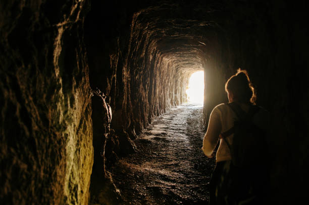 istock Woman walking inside a dark tunnel 1313269555