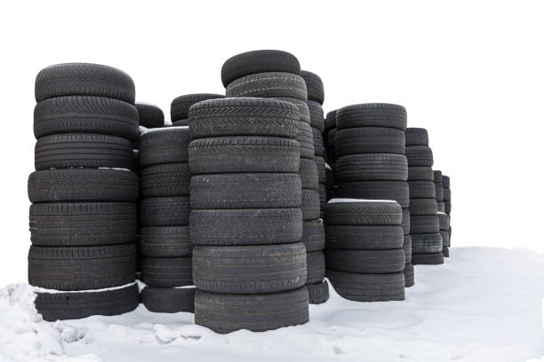 Piles of old tires standing in snow, white background