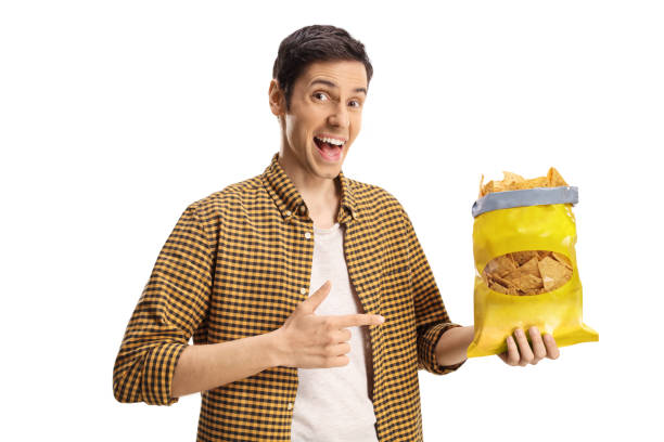 istock Young man holding a pack of tortilla chips and pointing 1313271318