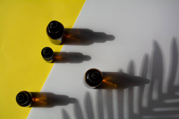 istock Set of bottles for cosmetics on yellow-white background with leaf shadow 1313271395