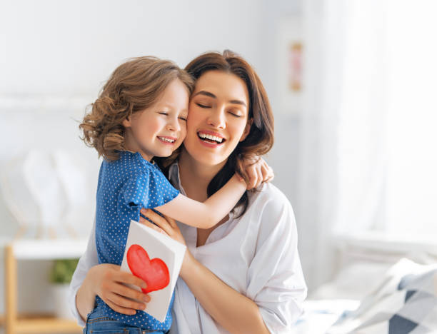 Happy mother's day Happy mother's day! Child daughter is congratulating mom and giving her postcard. Mum and girl smiling and hugging. Family holiday and togetherness. mother stock pictures, royalty-free photos & images