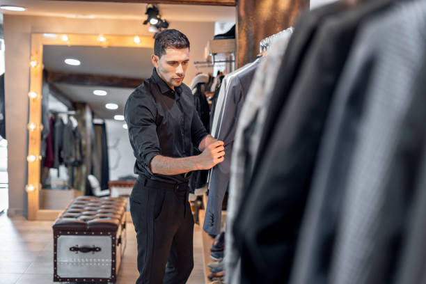 istock Man working in a clothing store organizing products 1313275274