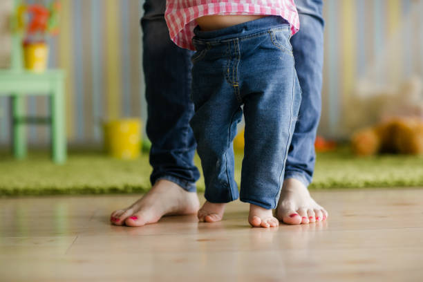 istock Baby taking first steps with mother's help at home. happy family concept 1313280717