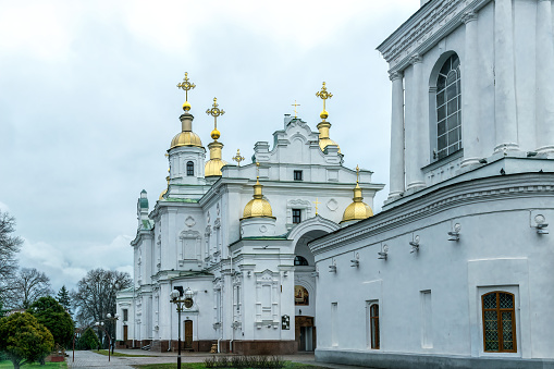 Poltava, Ukraine - April 14, 2021: Holy Dormition Cathedral of the Orthodox Church of Ukraine and a and a festive traditionally decorated sign \
