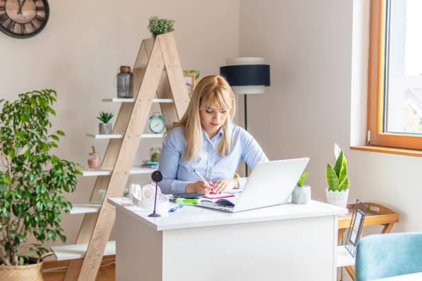 istock Young woman analyzing bills. Beautiful female is using laptop at table while working from home. Home office. 1313282737