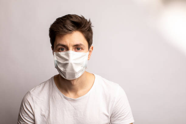 istock a man in a medical mask. Protection from coronavirus. white background 1313284090