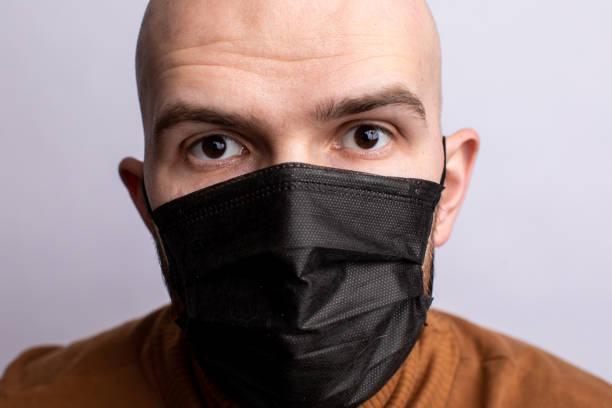 istock a man in a medical mask. Protection from coronavirus. white background 1313284273