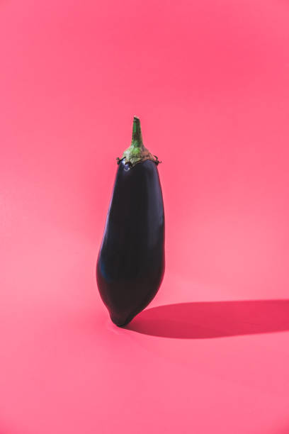 istock A black zucchini levitates over a pink background with a minimalist shadow 1313284346