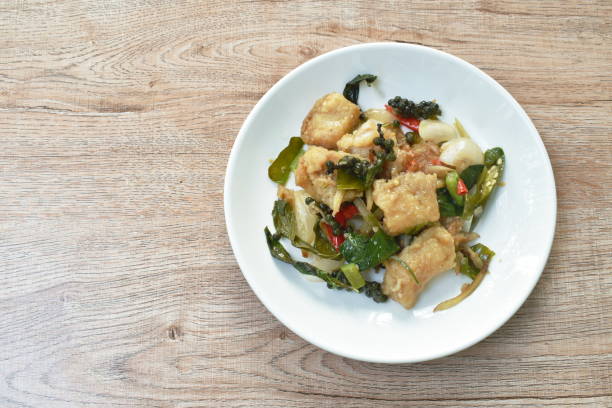 deep fried slice striped snake head fish with pepper and finger root on white dish
