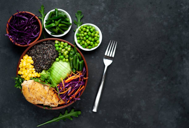 istock Bowl Buddha. Quinoa, chicken breast, avocado, red cabbage, arugula, carrot, green peas, corn, broccoli, green beans in a plate on a stone background, with copy space for your text 1313287193