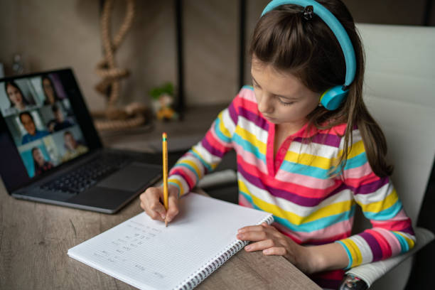 istock Child whit headphones doing her homework at home 1313288794