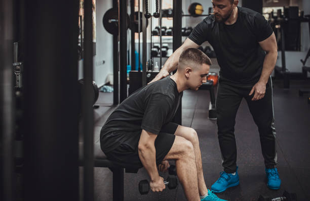 istock Man exercising with personal trainer gym 1313288870