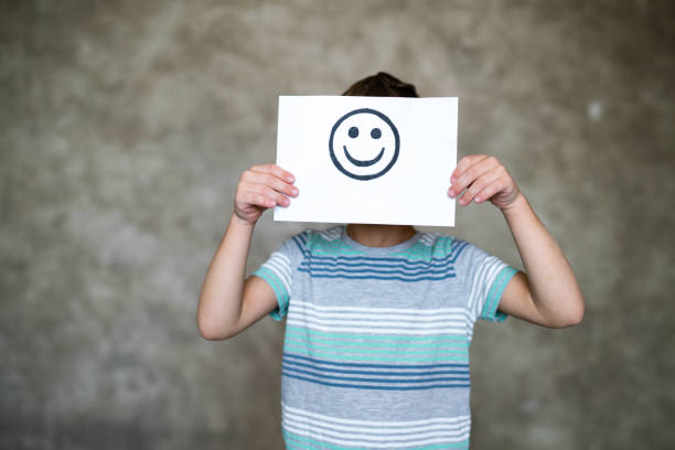 Child holding a smile face drawing. Happy emotion. Happy boy with smiley faces drawing anthropomorphic smiley face photos stock pictures, royalty-free photos & images