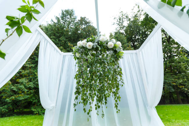 istock Wedding ceremony decorations: arch, decorated with crysanthemums, roses, hydrangeas. A lot of flowers in white and blue style, on a background of greenery 1313298985