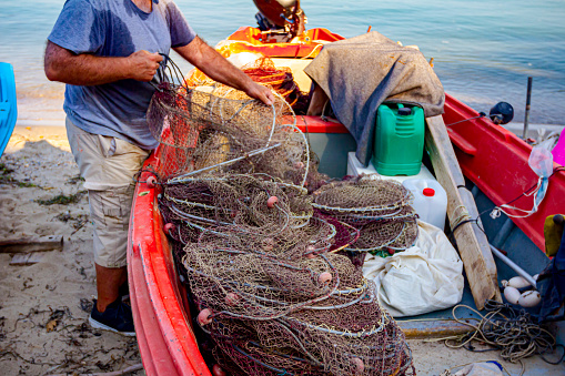 Fisherman is pile up fishing net and prepare for his next angling.