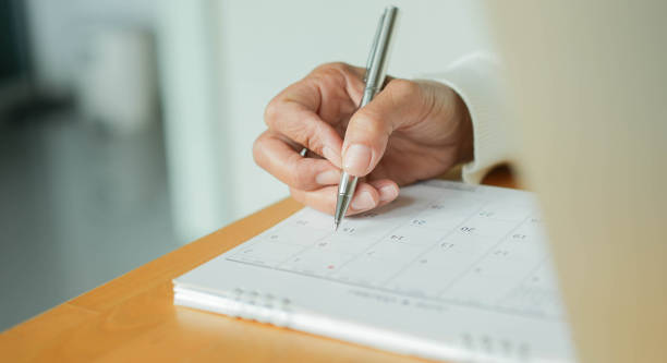 nahaufnahme auf seniorin hand verwenden stift auf kalender für termintreffen zu schreiben oder zeitplan jeden tag zu hause für die arbeit von zu hause konzept verwalten - 40 weeks stock-fotos und bilder