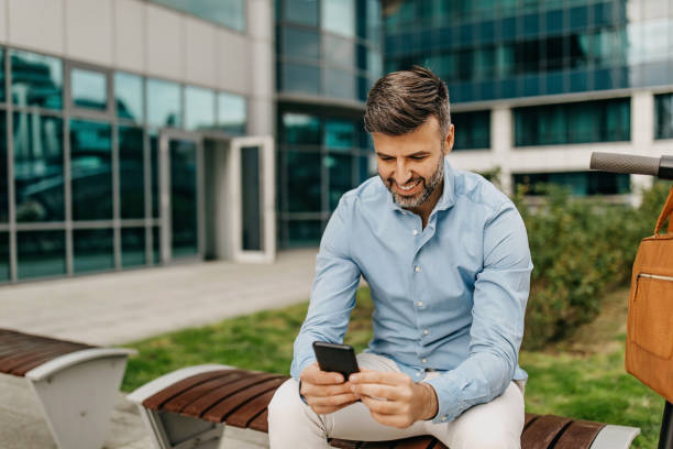 istock Young attractive man sitting on the bench and using phone 1313303003