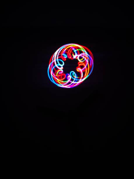 istock Closeup of Neon Multicoloured Spirograph geometric abstract pattern isolated in a Black background with copy space. Made using Long exposure technique. Geometric pattern. Pendulum pattern. 1313303446