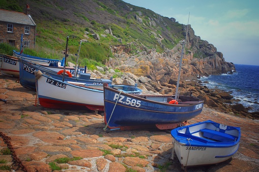 Penberth, Cornwall, UK - April 15, 2021: Small fishing boats and fisherman's cottage at Penberth, Cornwall, UK. Situated in west Cornwall, Penberth is now a popular travel destination.