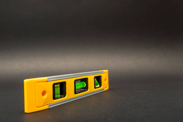 istock Building level in yellow on a black background. Construction tool, printable for postcard or poster, place for text 1313305580
