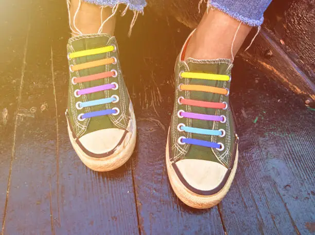 Close-up of pair of sneakers with colorful shoelaces.