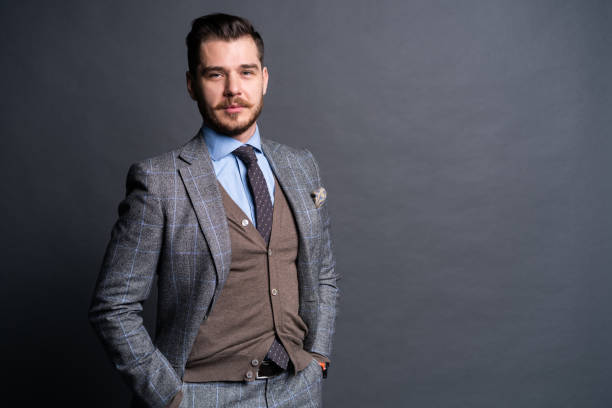 istock A confident elegant handsome young man standing in front of a grey background in a studio wearing a nice suit. 1313308467