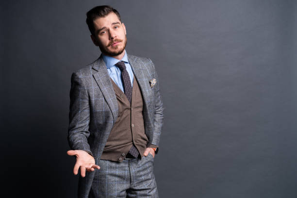 istock A confident elegant handsome young man standing in front of a grey background in a studio wearing a nice suit. 1313308477