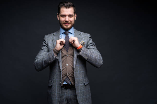 istock A confident elegant handsome young man standing in front of a black background in a studio wearing a nice suit. 1313308543
